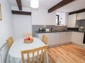 A kitchen with a dining table and chairs at Ivy Cottage in Abergele