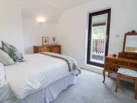 A bedroom with a bed and wooden furniture at Ivy Cottage in Abergele