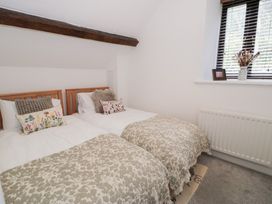 A bedroom with two beds and a window at Ivy Cottage in Abergele