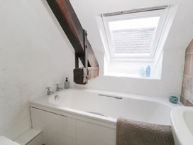 A bathroom with a bathtub and window at Ivy Cottage in Abergele