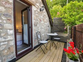 An outdoor area with a table and chairs at Ivy Cottage in Abergele