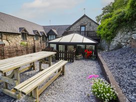An outdoor area with tables and flower pots at Ivy Cottage in Abergele