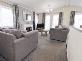 A living room with sofas and a television at Lily's Lodge in Morecambe