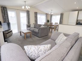 A living room with a sofa and dining area at Lily's Lodge in Morecambe