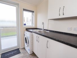 A laundry room with a washing machine and sink at Lily's Lodge in Morecambe