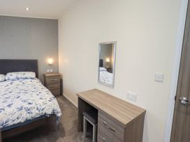 A bedroom with a bed and desk at Lily's Lodge in Morecambe