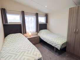 A bedroom with two beds and a wardrobe at Lily's Lodge in Morecambe