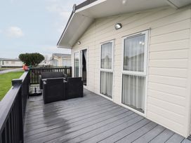 An outdoor area with a couch and windows at Lily's Lodge in Morecambe