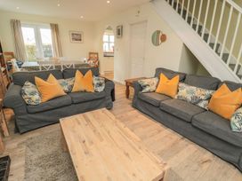 A living room with sofas and a coffee table at Sandy Cove in Chathill