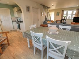 A dining room with a table and chairs at Sandy Cove in Chathill