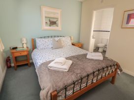 A bedroom with a bed and an adjoining bathroom at Sandy Cove in Chathill