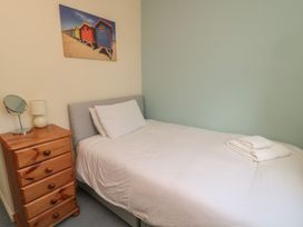 A bedroom with a bed and nightstand at Sandy Cove in Chathill