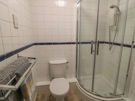 A bathroom with a shower and toilet at Sandy Cove in Chathill
