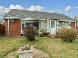 A bungalow with a garden and flower bed at Min Y Cae 