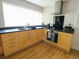 A kitchen with wooden cabinets and appliances at Min Y Cae in 