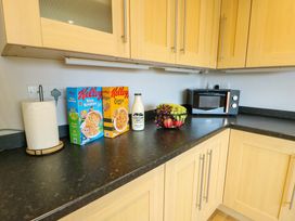 A kitchen countertop with cereal, milk, and a fruit bowl at Min Y Cae