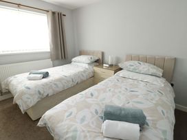 A bedroom with two single beds and a bedside table at Min Y Cae