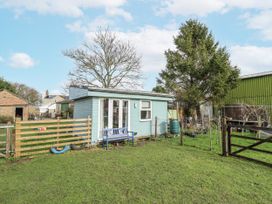 A cabin with a bench and trees at Mardi Gras in Wisbech