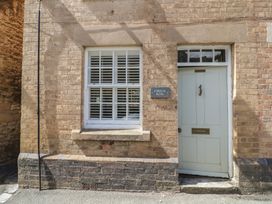 A door and window on a brick wall at Tea Tree Cottage in Chipping Campden