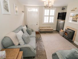 A living room with a sofa and fireplace at Tea Tree Cottage in Chipping Campden