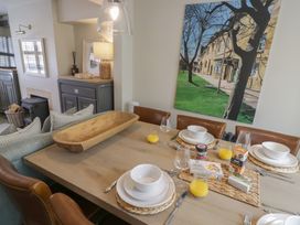 A dining room with a table set for a meal at Tea Tree Cottage in Chipping Campden