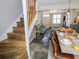 A living room with a dining area and staircase at Tea Tree Cottage in Chipping Campden