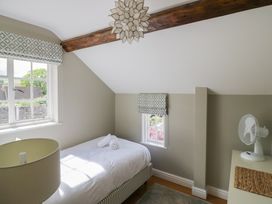 A bedroom with a bed and lamp at Tea Tree Cottage in Chipping Campden