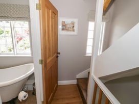A bathroom with a bathtub and staircase at Tea Tree Cottage in Chipping Campden