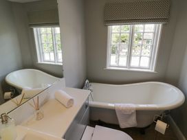 A bathroom featuring a bathtub and a washbasin at Tea Tree Cottage in Chipping Campden