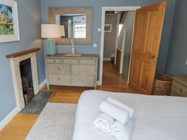 A bedroom with a bed and dresser at Tea Tree Cottage in Chipping Campden
