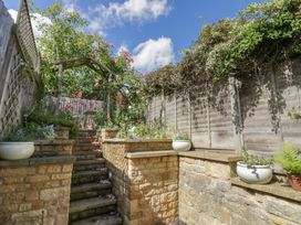 A garden with stairs and potted plants at Tea Tree Cottage in Chipping Campden