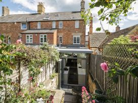 A garden with flowers and a view of a house at Tea Tree Cottage in Chipping Campden