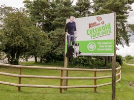 A sign for Cotswold Farm Park with a fence and trees nearby at Tea Tree Cottage, Chipping Campden