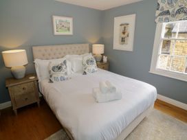 A bedroom with a bed and nightstand at Tea Tree Cottage in Chipping Campden