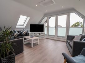 A living room with a television and a table at Mike’s Place in Rhyl