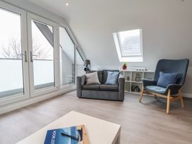 A living room with a sofa and armchair at Mike’s Place in Rhyl