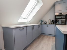 A kitchen with a sink and cabinets at Mike’s Place in Rhyl