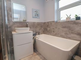 A bathroom with a bathtub and wash basin at Mike’s Place in Rhyl