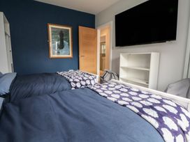 A bedroom with two beds and a television at Mike's Place in Rhyl