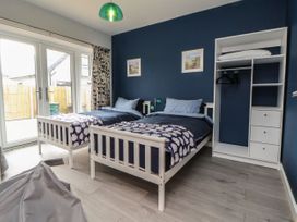 A bedroom with two beds and a wardrobe at Mike’s Place On The Cove Rhyl