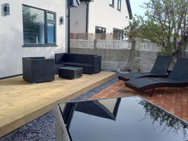 An outdoor seating area with a sofa and loungers at Mike’s Place On The Cove Rhyl
