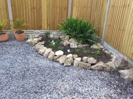A garden featuring a flower bed surrounded by rocks at Mike’s Place On The Cove in Rhyl