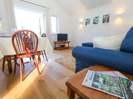 A living room with a dining area and television at The Pebble in Dorchester