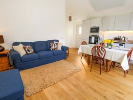A living room with a sofa and dining table at The Pebble in Dorchester