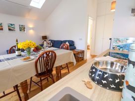 A dining room with a table and flowers at The Pebble in Dorchester