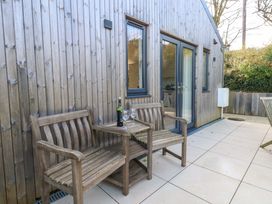 An outdoor patio with wooden benches and wine glasses at The Pebble in Dorchester