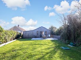 A garden with a house and patio furniture at The Pebble in Dorchester