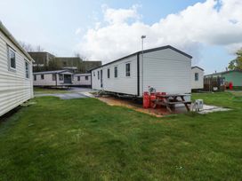 A caravan with a picnic table and gas bottles at Valley 36 in Kingsbridge