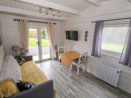 A living room with a sofa and dining table at Nellies Log Cabin in Kilcogy
