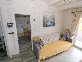A living room with a sofa and a painting at Nellies Log Cabin Kilcogy